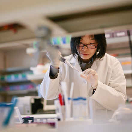 Researcher in laboratory with syringe 